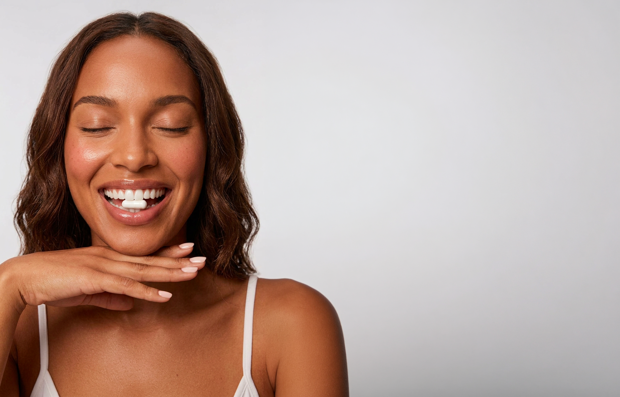 Modella sorridente con una capsula, immagine del brand Manetti Blanchard